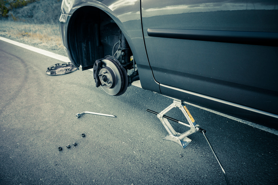 Changing a flat tire in London Ontario with tire jack